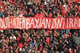 Football fans in Tabriz hold a red banner reading 'South Azerbaijan isn't Iran' during a match, expressing ethnic Azerbaijani nationalist sentiment in Iran