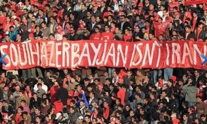Football fans in Tabriz hold a red banner reading 'South Azerbaijan isn't Iran' during a match, expressing ethnic Azerbaijani nationalist sentiment in Iran
