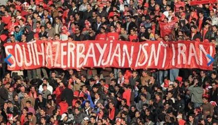 Football fans in Tabriz hold a red banner reading 'South Azerbaijan isn't Iran' during a match, expressing ethnic Azerbaijani nationalist sentiment in Iran
